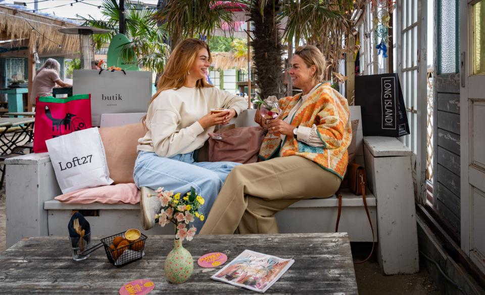 Moeder en dochter met cocktails op een bankje